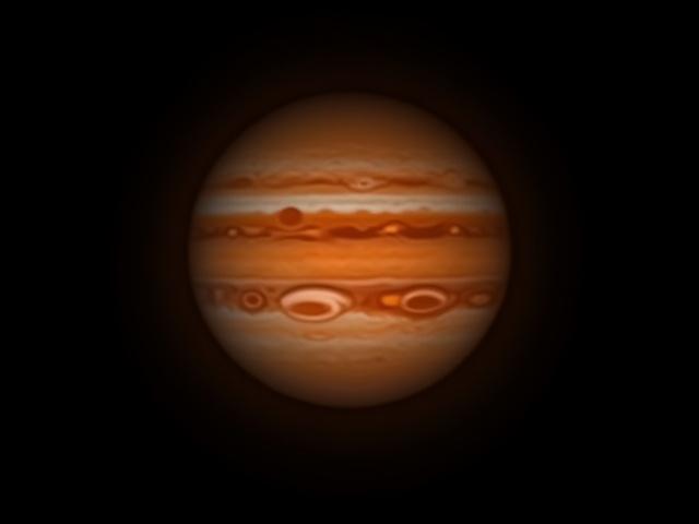 Close-up view of Jupiter with its Great Red Spot and four Galilean moons visible through a telescope